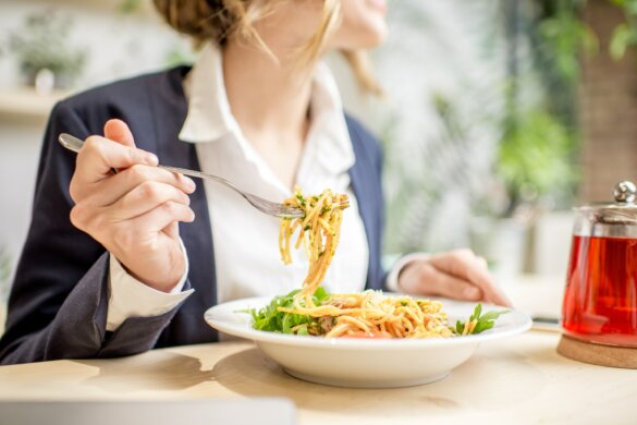Businesswoman eating pasta at the restaurant